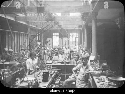 Una fotografia che raffigura uomini e donne che lavorano nella produzione di pipe, scattata da Kapp & Peterson. L'immagine mostra il lavoro e l'artigianato coinvolti nella produzione di tubi durante l'inizio del XX secolo. Foto Stock