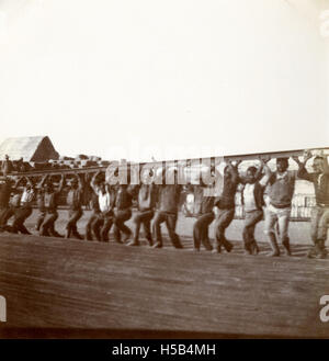 Una fotografia storica di un gruppo di lavoro intorno al 1901, che probabilmente mostra lavoratori impegnati in lavoro o costruzione. Questa immagine riflette la cultura del lavoro e i movimenti operai dei primi anni del XX secolo. Foto Stock