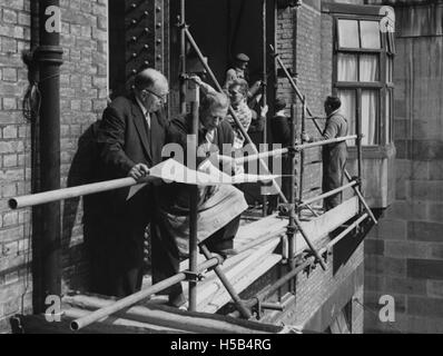 Questa immagine raffigura i lavori di costruzione di un ampliamento del cortile nel 1964, mostrando lo sviluppo della proprietà e i cambiamenti architettonici apportati allo spazio durante quel periodo. Foto Stock