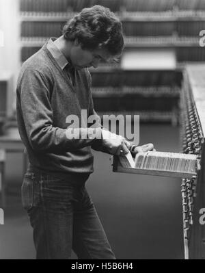 Studente utilizzando la scheda Catalogo della biblioteca, 1981 Foto Stock
