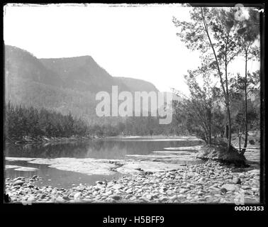 Questo paesaggio del fiume cattura una vista panoramica lungo il fiume Hawkesbury nel nuovo Galles del Sud, in Australia, probabilmente dal 1880 al 1909. L'immagine mostra il paesaggio naturale e il significato storico del fiume come percorso di trasporto. Foto Stock