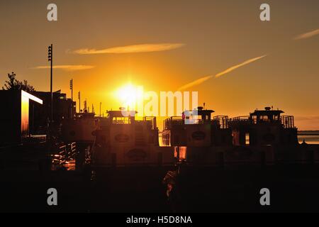 Il sorgere del sole sopra e riflettendo sul taxi acquei legato lungo Chicago il Navy Pier su una tarda mattina d'estate. Chicago, Illinois, Stati Uniti d'America. Foto Stock