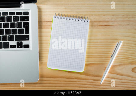 Vuoto portatile blocco note e penna sulla scrivania in legno Foto Stock