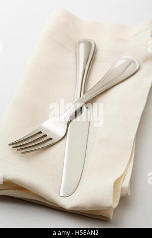 Semplice e classica impostazione tabella di impostazione del luogo con alta qualità di posate coltello e forchetta sulla biancheria da letto bianca igienico. Foto Stock