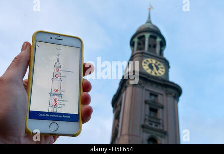 Amburgo, Germania. Xix oct, 2016. Illustrazione - Il MichelAPP è aperta su uno smartphone nella parte anteriore del Michaelis chiesa (noto come 'Michel') ad Amburgo, Germania, 19 ottobre 2016. L'app consente di esplorare il famoso edificio. Foto: Axel HEIMKEN/dpa/Alamy Live News Foto Stock