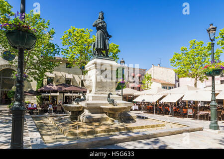 Statua di Saint Louis su un plinto di fontana nel cafe rivestito posto Saint-Louis, Aigues Mortes, Nimes, Gard, Francia Foto Stock