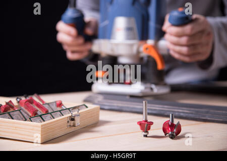 Falegname che lavora il legno con una macchina di fresatura Foto Stock