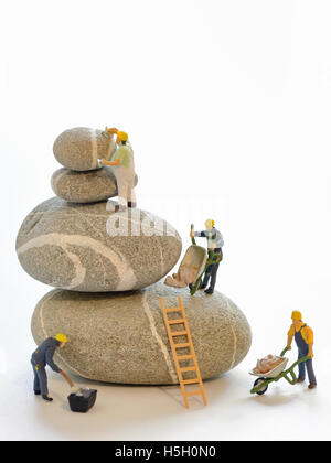 Stack di ciottoli e figurine di lavoratori edili Foto Stock