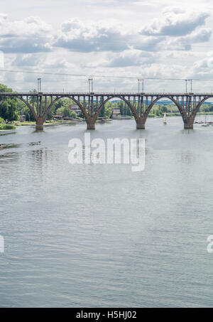 Alta arcuata di un ponte ferroviario in calcestruzzo di fronte fiume Dnieper nella città Dnepropetrovsk. Foto Stock