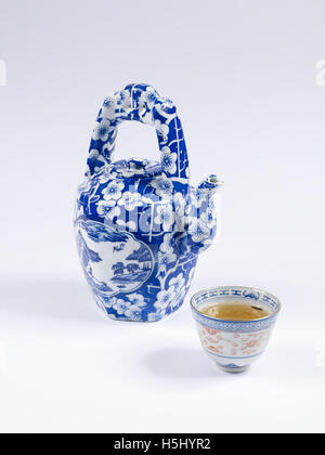 Tè verde servito in una tazza su sfondo bianco Foto Stock