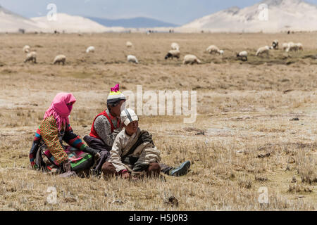 Famiglia tibetana seduto sull'erba. Foto Stock