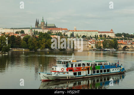 Tour in barca sul fiume Moldava a Praga, Repubblica Ceca. Hradcany Castle in distanza. Foto Stock