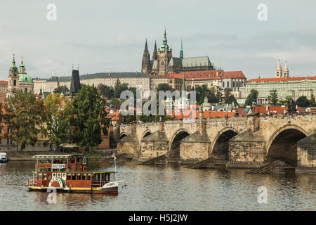 Tour in barca sul fiume Moldava a Praga, Repubblica Ceca. Il Ponte Carlo e il castello di Hradcany nella distanza. Foto Stock