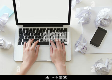Le mani a lavorare con un computer portatile sul bianco scrivania in ufficio Foto Stock
