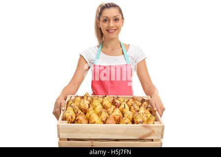 Felice fornitore femmina tenendo una gabbia piena di pere isolati su sfondo bianco Foto Stock