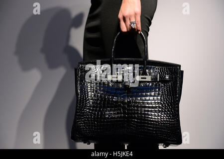 Un Christie's dipendente modelli la Hermes, eccezionali Shiny Bleu Marine Porosus coccodrillo Diamond Birkin 35 con diamanti e oro bianco 18K borsa hardware e la stella della Sierra Leone anello con diamante Cartier bracciale. Foto Stock