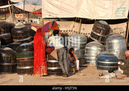 Naguar, Rajasthan, India- Febbraio 10, 2011: una famiglia di Rajasthani vendita cestelli metallici per memorizzare gli utensili al Naguar fiera del bestiame a Naguar, Rajasthan Foto Stock