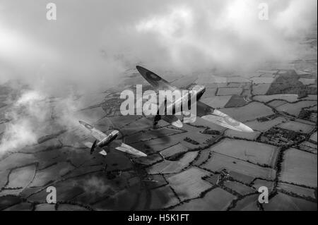 Una rappresentazione di Supermarine Spitfire Mk I combattenti dal 65 Squadron, nella Battaglia di Bretagna camouflage, sulla campagna inglese. Foto Stock