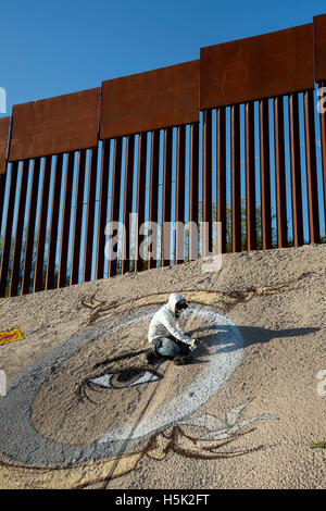 Nogales, Sonora Messico - artisti di graffiti dipinge un design sotto gli Stati Uniti-Messico recinzione di confine. Foto Stock