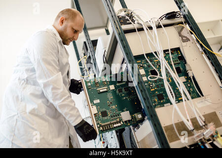 Tecnico operante nella scheda di rete labaratory Foto Stock