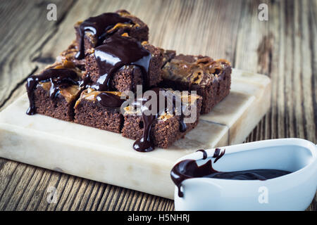 In casa caramello brownie al cioccolato con cioccolato fondente ganache servita su piedistallo di marmo Foto Stock