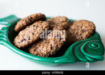 Alcuni gustosi biscotti appena sfornati su un verde piatto di pesce Foto Stock