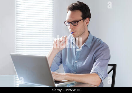 I giovani adulti il freelance che lavorano a casa con il computer portatile e penna e ottengo ispirazione, concetto di imprenditore o nella finestra di progettazione Foto Stock