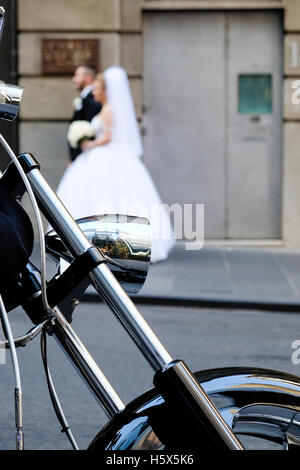 In prossimità della ruota di moto parcheggiate su Flinders Lane, Melbourne, Victoria, Australia, con la sposa e lo sposo a camminare su strada Foto Stock