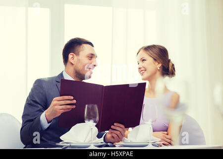 Coppia sorridente con menu al ristorante Foto Stock