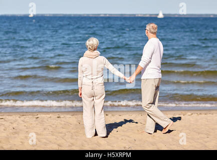 Felice coppia senior holding hands estate spiaggia Foto Stock