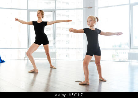 Carino bambina ballerina ballando con il suo insegnante di danza studio Foto Stock