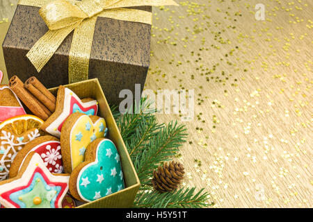 Le decorazioni di Natale con confezioni regalo e gingerbread cookie su fondo oro Foto Stock