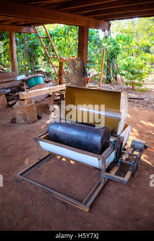 La tostatura del caffè macchina utilizzata dal sig. Vieng al suo caffè smallholding sul Bolaven Plateau Foto Stock