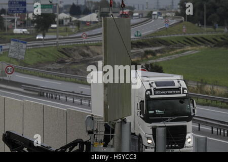 Calais, Francia. Il 21 ottobre 2016. Un nuovo segmento è abbassata in parete. I lavoratori continuano a costruire la parete sulla strada di avvicinamento al porto di Calais, nonostante il previsto lo sfratto del rifugiato a camma 'giungla' cary la prossima settimana. Il muro è costruito in modo da impedire ai rifugiati dalla vicina giungla campo per accedere all'autostrada, dove si tenta di interrompere il traffico a sneak su camion sulla strada per il Regno Unito. Credito: Michael Debets/Alamy Live News Foto Stock