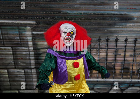 Un killer clown Halloween con maschera, faccia bianca, i capelli rossi parrucca, e urlando scary espressione, Southport, Merseyside, Regno Unito Foto Stock