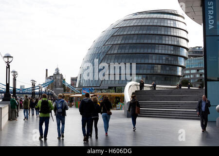 La gente camminare lungo la riva sud dal Municipio di Londra, Regno Unito Foto Stock