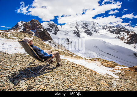 Giovane uomo godendo della splendida vista del Morteratsch ghiacciaio Diavolezza vicino a Sankt Moritz, Svizzera Foto Stock