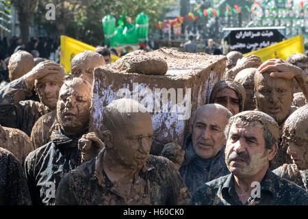 10 Muharram (Ashura), Bijar, uomini coperto di fango che trasportano Imam Hussain la bara durante la processione Foto Stock