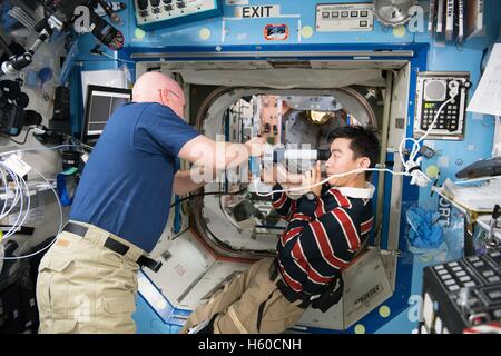 La NASA Stazione Spaziale Internazionale Expedition 44 astronauta missione Scott Kelly assiste astronauta giapponese Kimiya Yui della Japan Aerospace Exploration Agency nel prendere immagini retiniche di un costante salute oculare studio Agosto 5, 2015 mentre in orbita intorno alla terra. Foto Stock