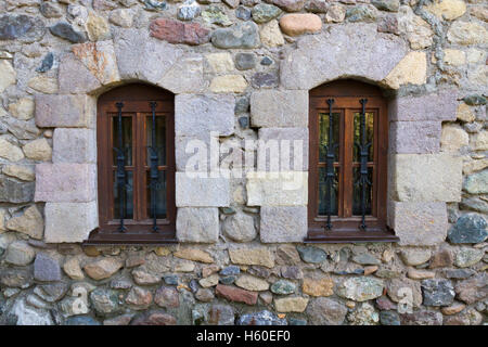 Due finestre su un vecchio muro di pietra in Dilijan, Armenia Foto Stock