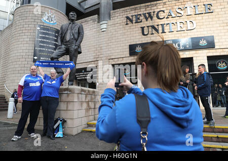 I fan di Ipswich posano per le foto con il sir Bobby Robson statua durante il cielo di scommessa match del campionato a St James Park, Newcastle. Foto Stock