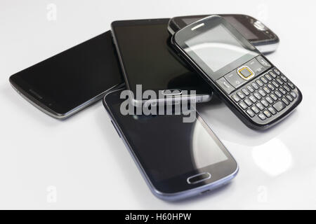 Pila di nuovi e vecchi telefoni cellulari Foto Stock