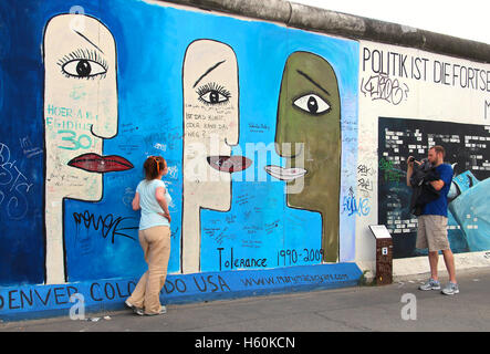 La gente che prende le immagini all'East Side Gallery, la più grande galleria d'arte a cielo aperto in tutto il mondo, dipinta sul segmento del muro di Berlino Foto Stock