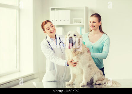 Donna felice con il cane e medico presso clinica veterinaria Foto Stock