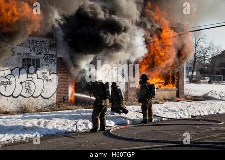 I vigili del fuoco di estinzione di incendi vacante edificio commerciale, Detroit, Michigan STATI UNITI Foto Stock