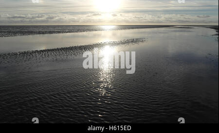 Sole bianco sopra l'orizzonte nubi stratocumulus con raggi splendenti di acqua di mare di attraversamento del canale sabbia distesa di spiaggia, Fairhaven, Lytham Foto Stock