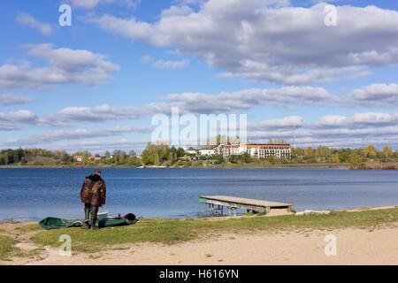 VILNIUS, Lituania - 16 ottobre 2016: la ventola di Fisher nella moderna tuta gonfia la barca in gomma sul banco di sabbia di publi Foto Stock