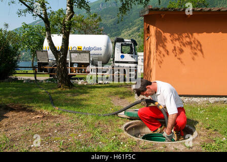 Melano, Svizzera -20 Maggio 2005: lavoratore rendendo la fornitura di gas su di un serbatoio nel giardino di una casa a Melano sulla Svizzera Foto Stock