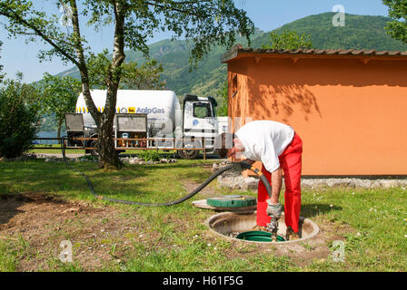 Melano, Svizzera -20 Maggio 2005: lavoratore rendendo la fornitura di gas su di un serbatoio nel giardino di una casa a Melano sulla Svizzera Foto Stock