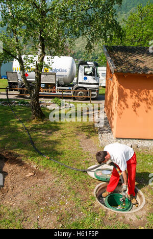 Melano, Svizzera -20 Maggio 2005: lavoratore rendendo la fornitura di gas su di un serbatoio nel giardino di una casa a Melano sulla Svizzera Foto Stock